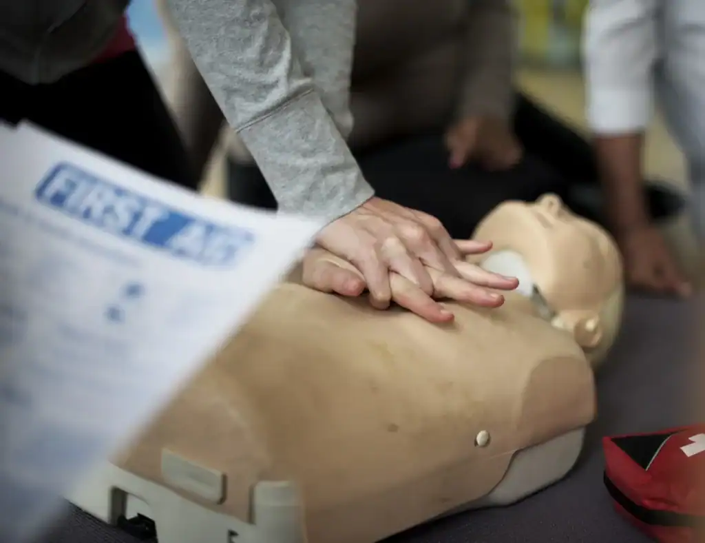 Person performing CPR on training mannequin.